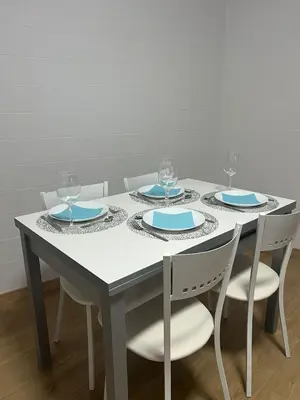 a table with four plates and wine glasses on it at Casco histórico Allariz-Iria in Allariz