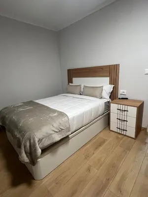 a bedroom with a large bed and a night stand at Casco histórico Allariz-Iria in Allariz