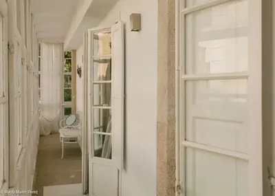 a hallway with an open door and a chair at A galería do san Ramón in Villalba
