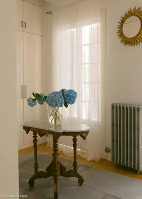 a vase of blue flowers on a table in a room at A galería do san Ramón in Villalba