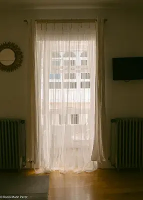 a window with white curtains in a room at A galería do san Ramón in Villalba