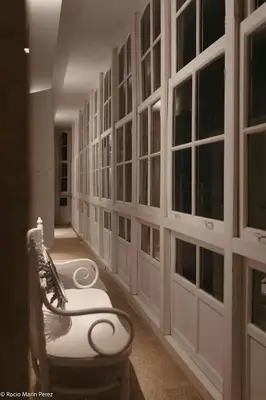 a hallway with a bench and a wall of windows at A galería do san Ramón in Villalba