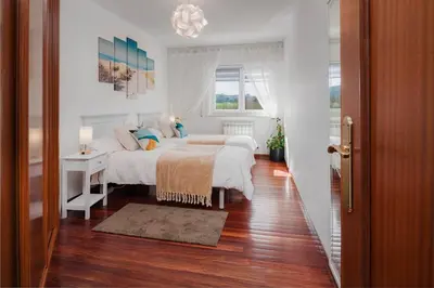 a white bedroom with two beds and a desk at Mirador del Tambre Etapa final del Camino in Sigüeiro