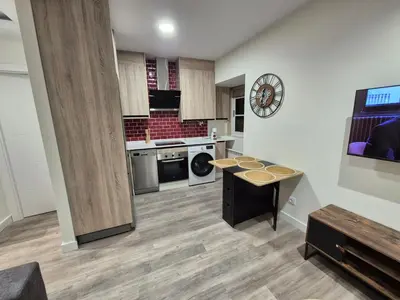 a large kitchen with a table in the middle at Escola in Ourense