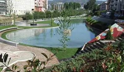a pond in the middle of a city at O lar da luz in Ourense