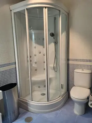 a shower stall in a bathroom with a toilet at O lar da luz in Ourense