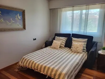a bedroom with a bed with a striped bedspread at O lar da luz in Ourense