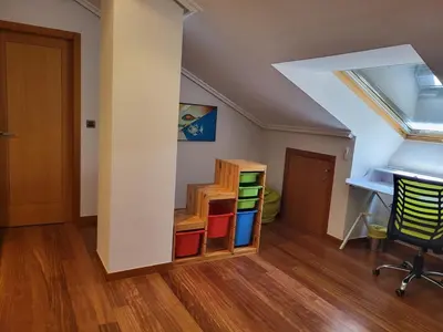 an attic room with a desk and a desk at O lar da luz in Ourense