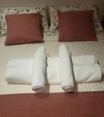 a bed with white towels and pillows on it at O lar da luz in Ourense