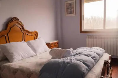 a bedroom with a bed with white pillows and a window at The Dragon's Lair in Piñeiro