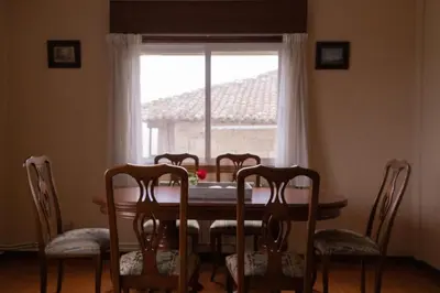 a dining room table with four chairs and a window at The Dragon's Lair in Piñeiro