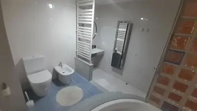 a white bathroom with a toilet and a sink at Ameli House By PECA in Silleda