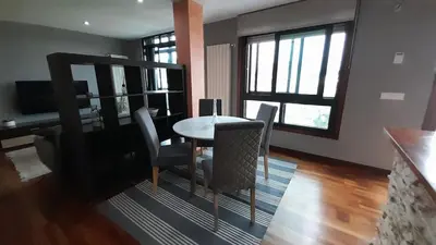 a dining room with a table and chairs and windows at Ameli House By PECA in Silleda