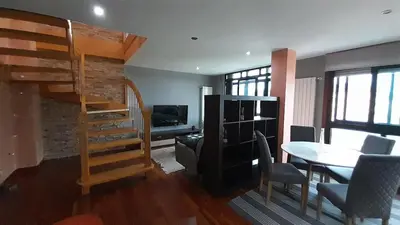 a living room with a loft bed and a table at Ameli House By PECA in Silleda