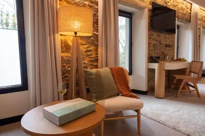 a living room with a table and a chair at Hotel Sarela Natura in Santiago de Compostela