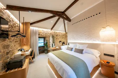 a bedroom with a bed and a desk in a room at Hotel Sarela Natura in Santiago de Compostela
