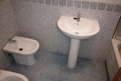 a bathroom with a sink and a toilet at Winahost Ático Viveiro in Viveiro