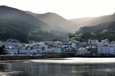 a town next to a body of water with buildings at Winahost Ático Viveiro in Viveiro