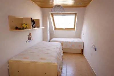 a small room with two beds and a window at Winahost Ático Viveiro in Viveiro