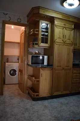 a kitchen with wooden cabinets and a microwave at Chuca House in Requiás