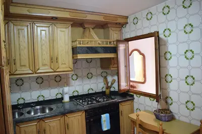 a kitchen with wooden cabinets and a stove top oven at Chuca House in Requiás