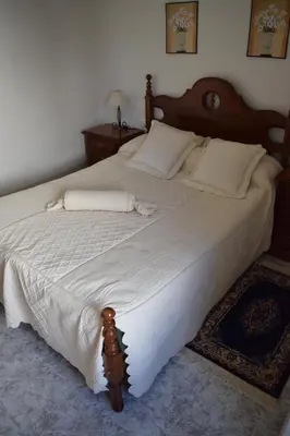a bedroom with a large bed with white sheets at Chuca House in Requiás
