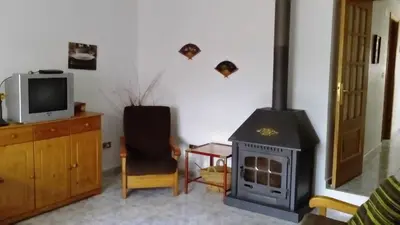 a living room with a fireplace and a tv at Chuca House in Requiás