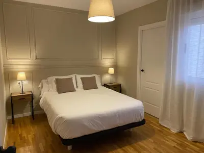 a bedroom with a white bed with two lamps and a window at Pensión Camino del Sil in Sobradelo