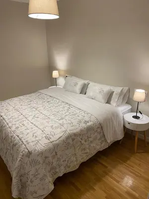a bedroom with a large bed with two tables and two lamps at Pensión Camino del Sil in Sobradelo