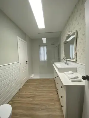 a white bathroom with a sink and a mirror at Pensión Camino del Sil in Sobradelo