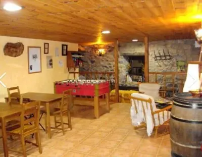 a room with tables and chairs and a room with a barrel at Mirador de Babia II in Ríolago