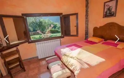 a bedroom with a large bed and a window at Mirador de Babia II in Ríolago