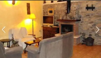 a living room with two couches and a fireplace at Mirador de Babia II in Ríolago