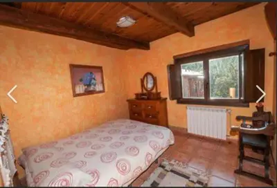 a bedroom with a bed and a window and a desk at Mirador de Babia II in Ríolago