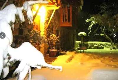 a picture of a snow covered yard in front of a house at Mirador de Babia II in Ríolago