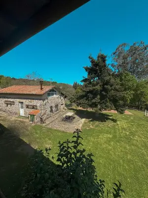 a stone building in a field with a tree at Aldea Figueiredo in San Amaro