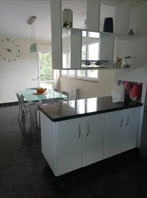 a kitchen with white cabinets and a dining table at Casa D Aitana in Pardaces de Arriba