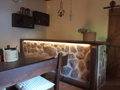 a dining room with a table and a stone wall at O Caliu das Airas in León
