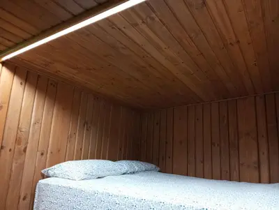 a bedroom with a wooden ceiling with a bed at O Caliu das Airas in León
