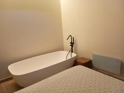 a bathroom with a bath tub next to a bed at O Caliu das Airas in León
