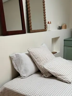 a bed with two pillows and two mirrors on the wall at O Caliu das Airas in León