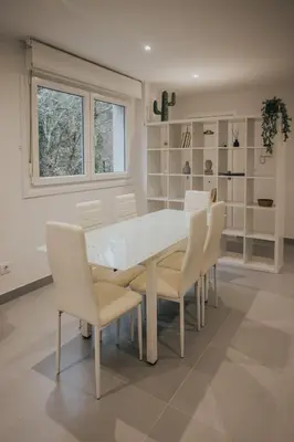 a dining room with a white table and chairs at Casas del Pedregal Apartamento 1 in A Estrada