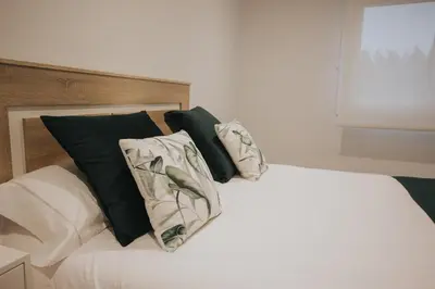 a bed with black and white pillows on it at Casas del Pedregal Apartamento 1 in A Estrada