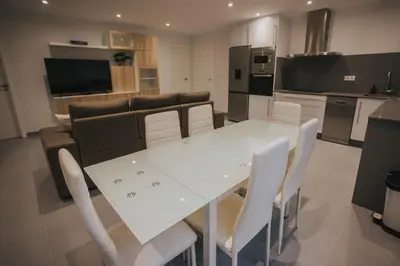 a white dining table and chairs in a kitchen at Casas del Pedregal Apartamento 1 in A Estrada