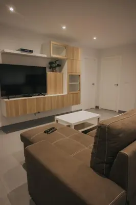 a living room with a couch and a flat screen tv at Casas del Pedregal Apartamento 1 in A Estrada