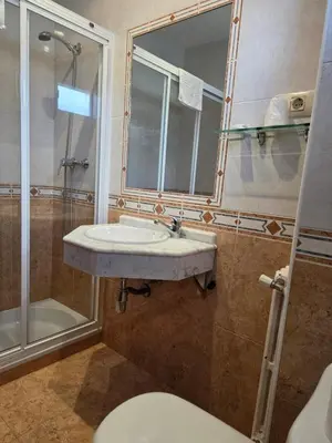 a bathroom with a sink and a shower and a toilet at Hotel Espada in A Rua