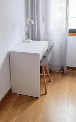 a white desk with a lamp and a chair at Alice House in Miño