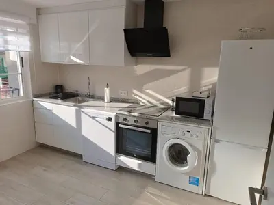 a kitchen with a washing machine and a refrigerator at Vivienda Ares Centro in Ares