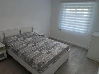 a white bedroom with a bed and a window at Vivienda Ares Centro in Ares