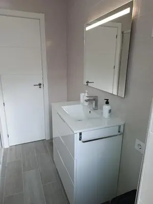 a white bathroom with a sink and a mirror at Vivienda Ares Centro in Ares